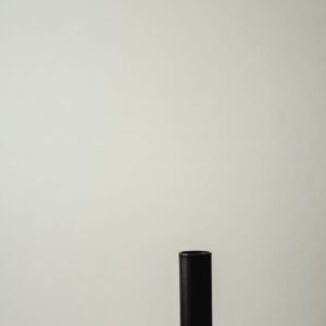 A japandi-style candle holder with a minimalist design against a gray background.