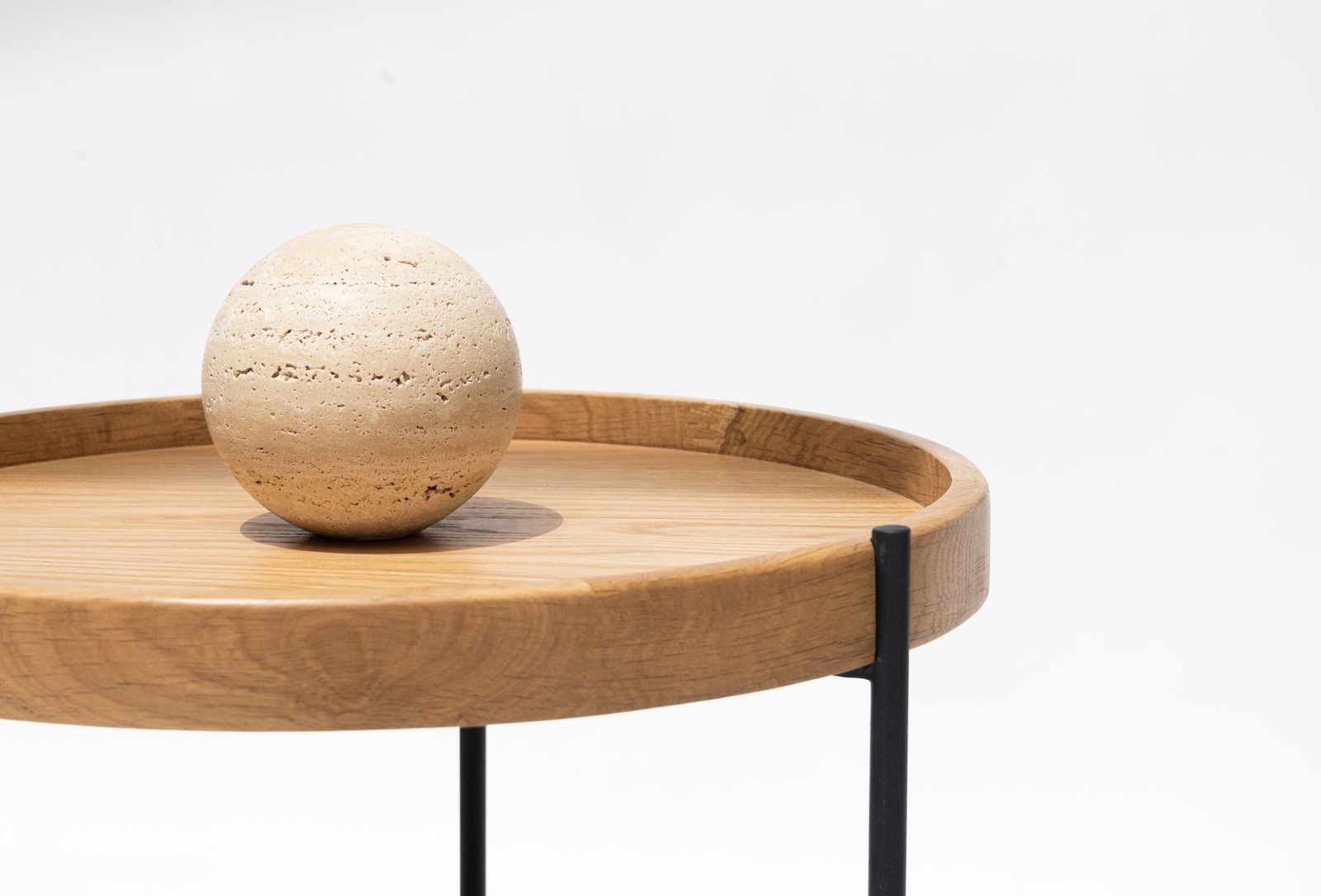A minimalist wooden table featuring a spherical ornament, perfect for interior design inspiration.
