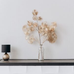 A stylish minimalist interior with a floral arrangement and a sleek lamp on a wooden table.