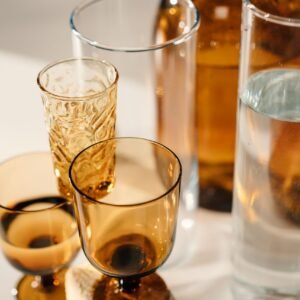Artistic arrangement of various glasses casting serene shadows on a surface.