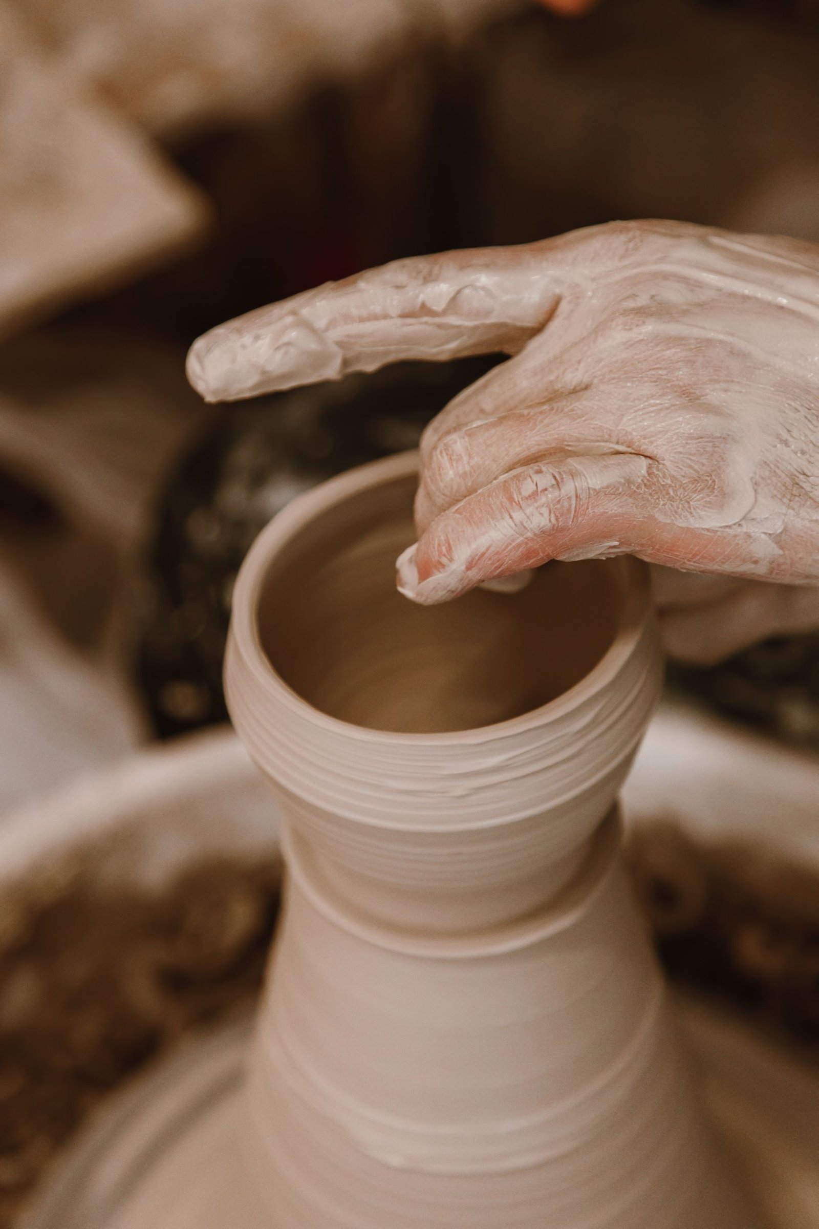 Mains façonnant un vase en céramique sur un tour de potier